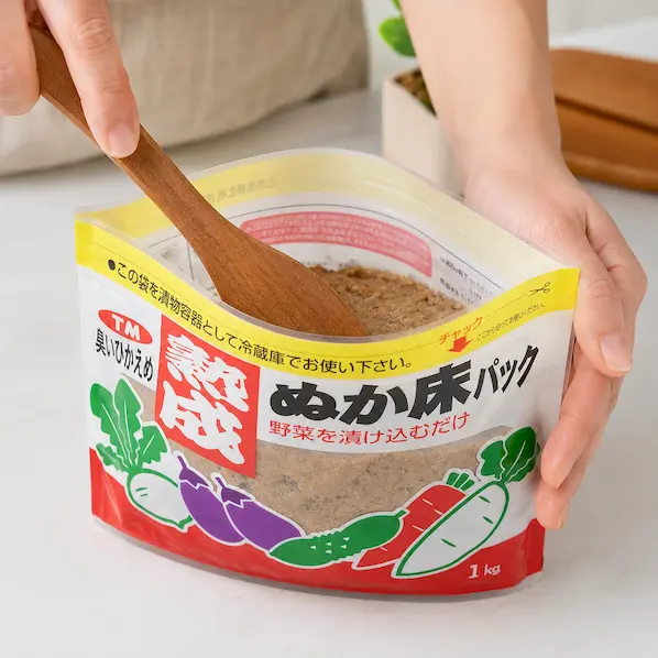 熟成ぬか床パックの中のねり床をスプーンで平らにならしている工程