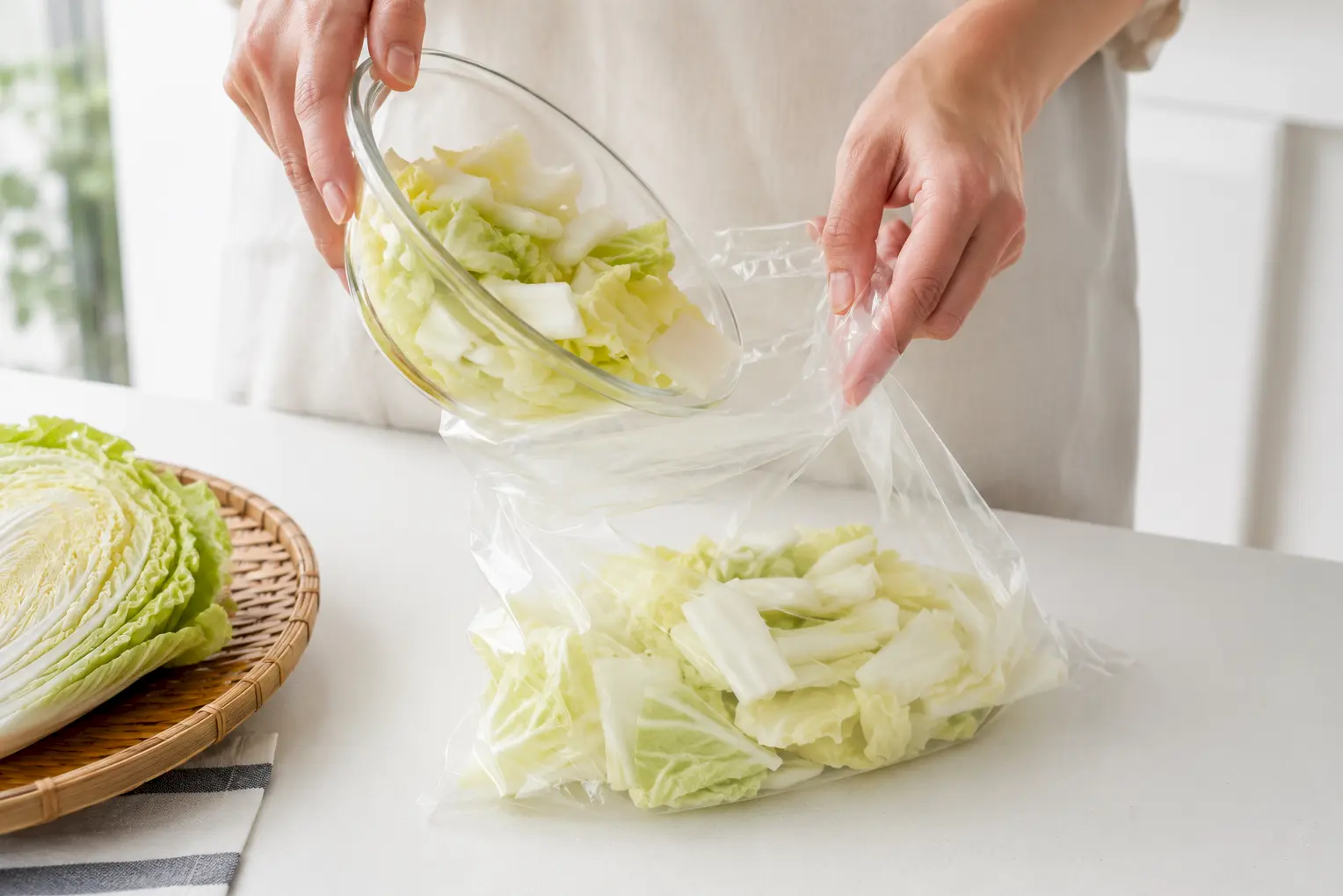 切った白菜を透明なポリ袋に入れる工程