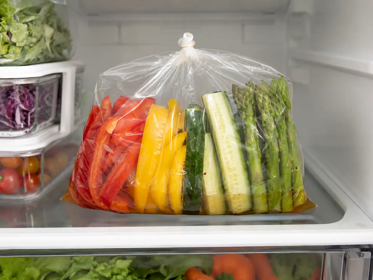 空気を抜いて口をしばったカラフル野菜の袋を冷蔵庫で漬けている工程