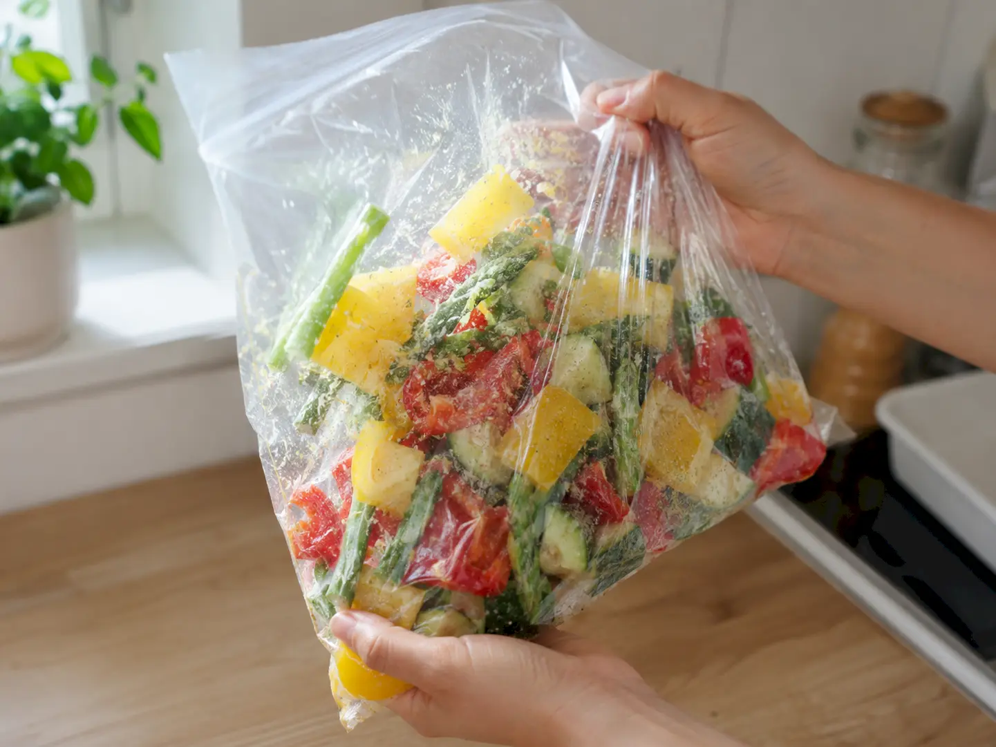 ポリ袋へ少し空気を入れてカラフル野菜とあさ漬の素を振り混ぜている工程