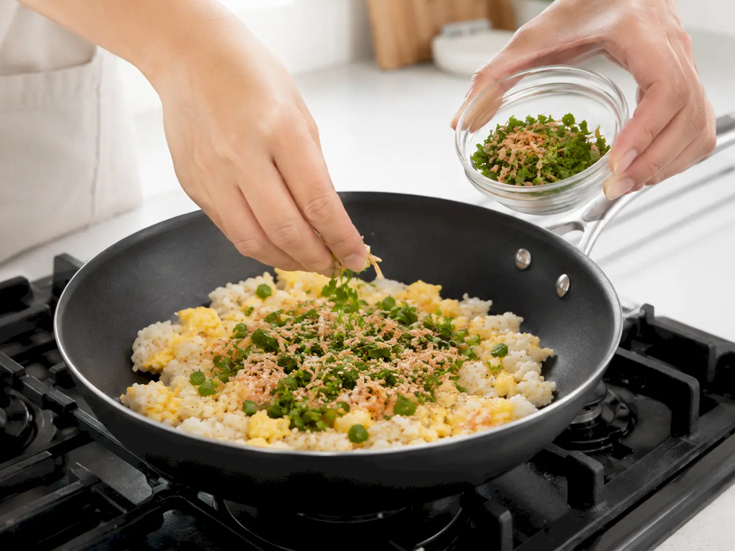 ご飯と玉子へ水菜漬け、乾燥桜えび、いりごまを加えている工程