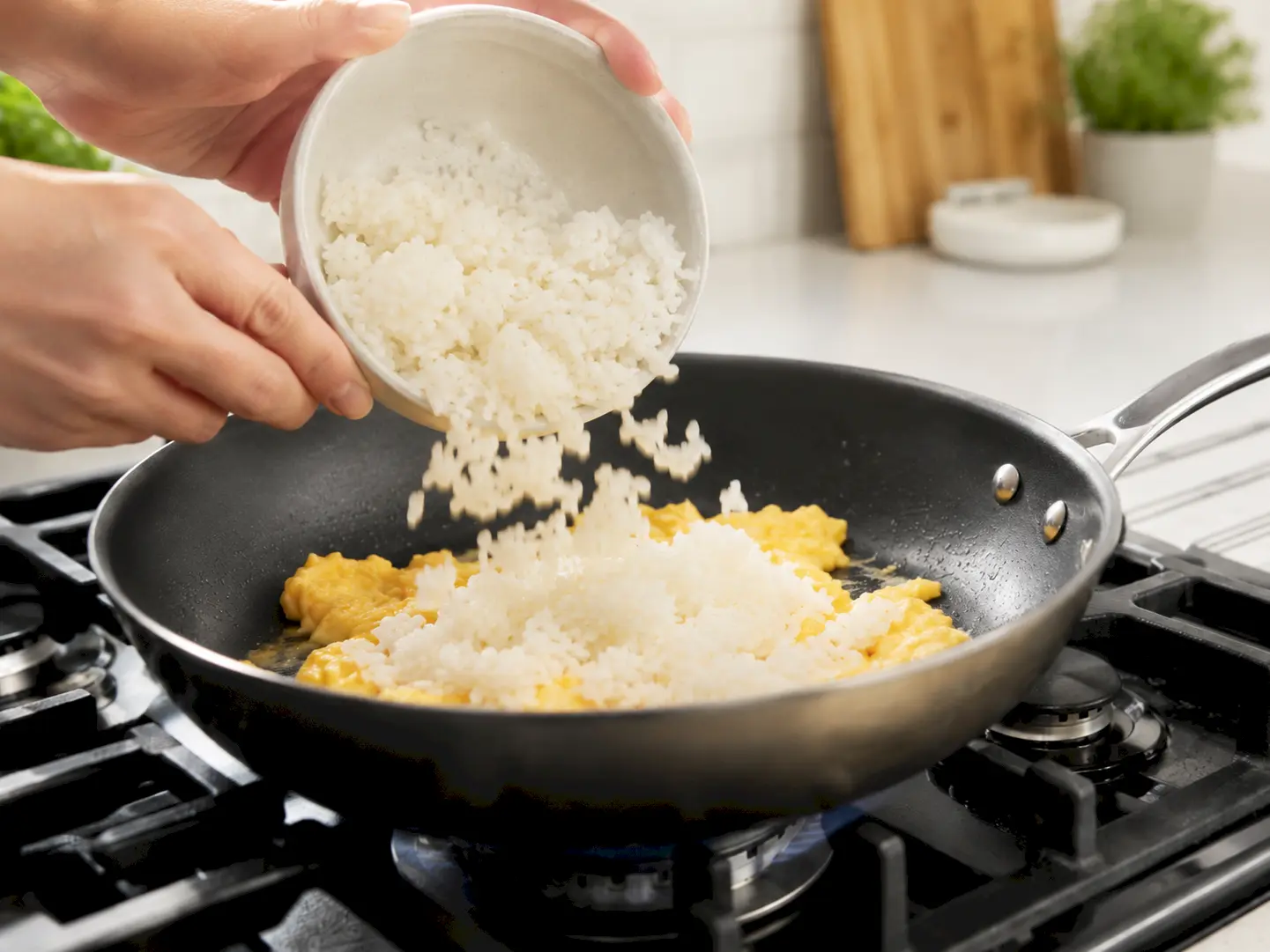 半熟状の玉子へほぐしたご飯を加えている工程
