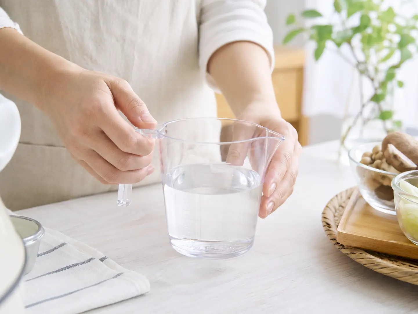 透明な計量カップで水400mlを量っている工程