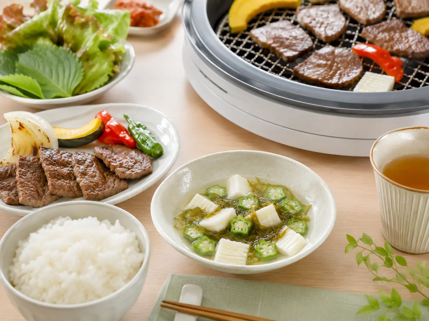 焼肉料理の後へオクラと山芋の水キムチを小鉢で添えた家庭の食卓