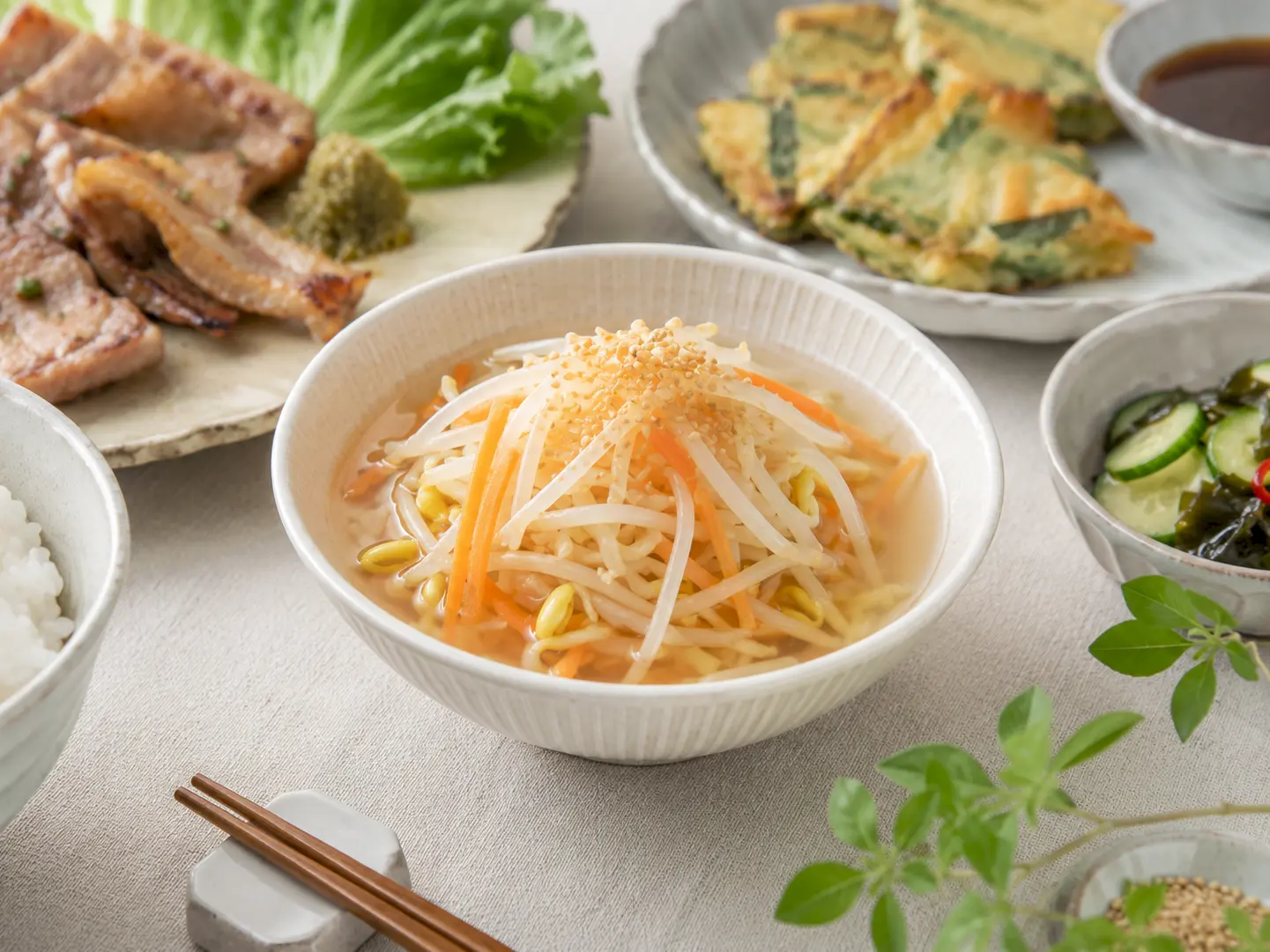 冷製もやしの水キムチを複数の小鉢へ盛り付けた家庭の食卓