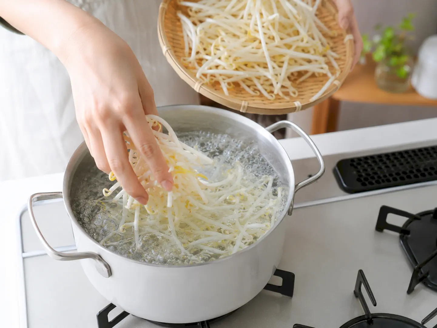 食塩入りの沸騰湯でもやしをサッと下ゆでしている工程