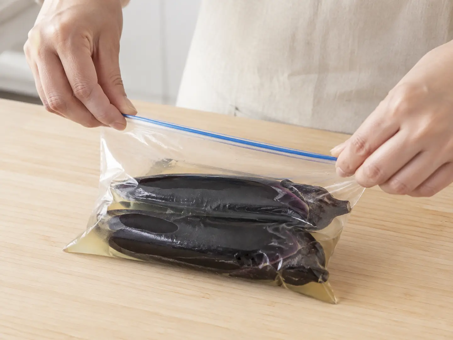 なすと漬け液の入った保存袋の口をしっかり閉じている工程