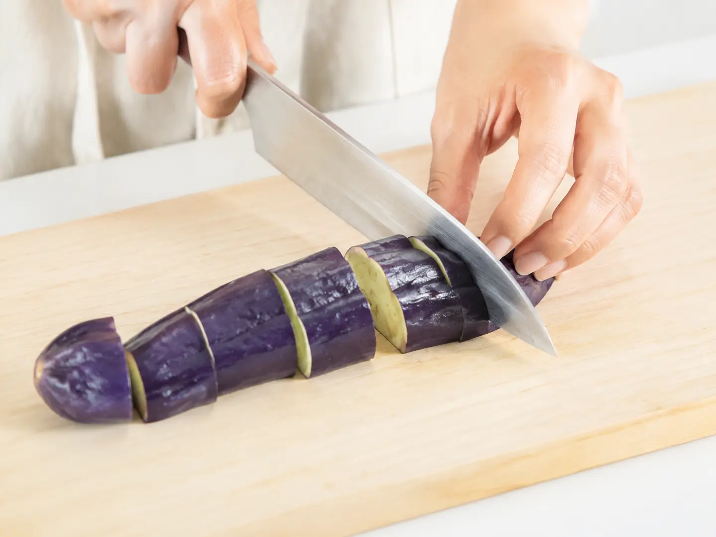 なすを清潔な包丁で食べやすい大きさへ切っている工程