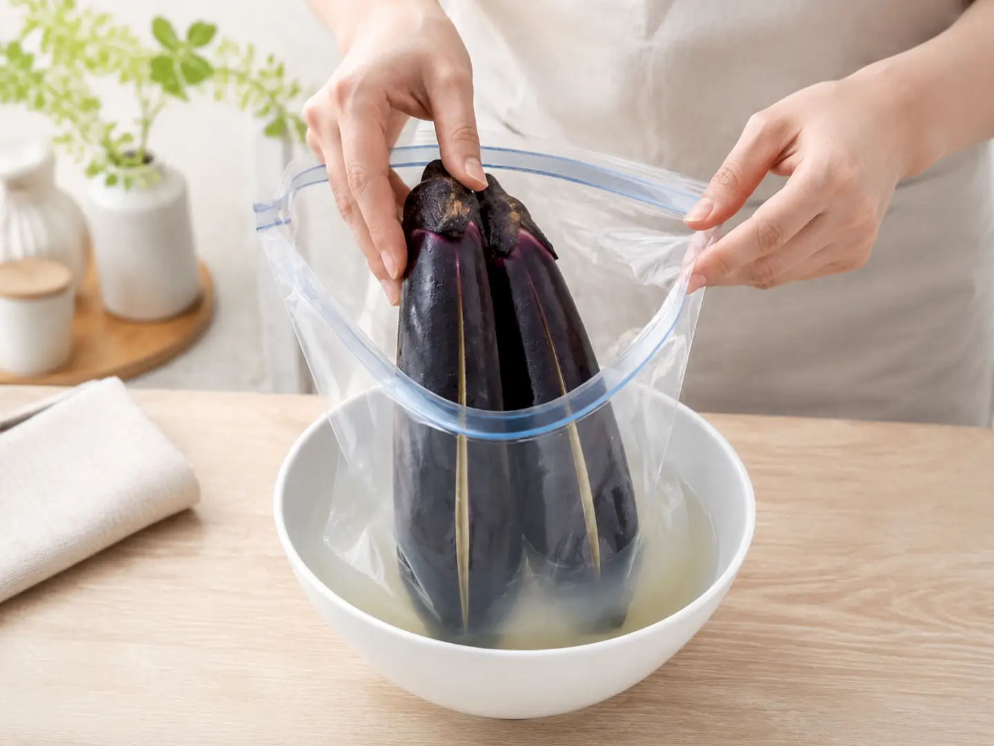 切ったなすを調味液の入った保存袋へすぐ入れている工程