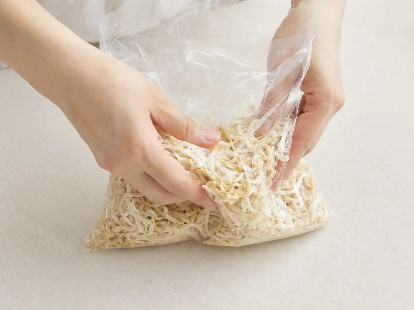 食品用ポリ袋で切り干し大根と粉末調味料を全体へ均一になじませる手元