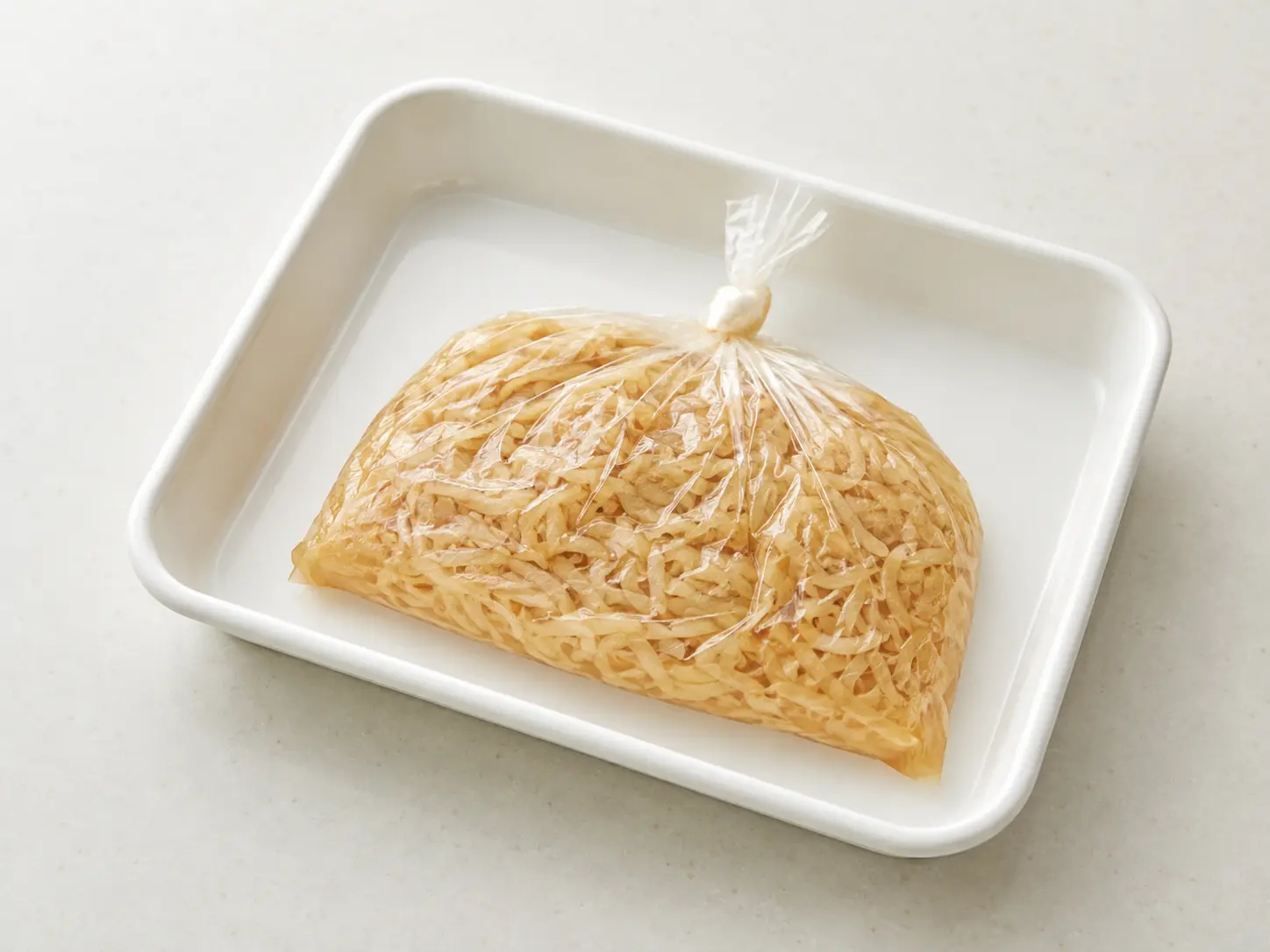 切り干し大根入りの食品用ポリ袋から空気を抜き清潔な容器へ載せた状態