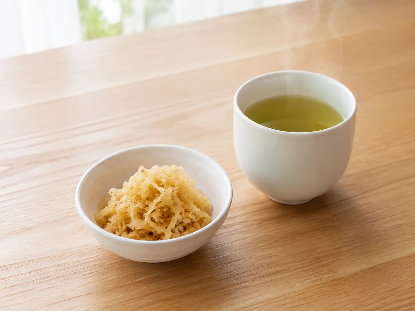 パリパリ干し大根漬けの小鉢と温かい日本茶を明るい木の食卓へ並べた様子