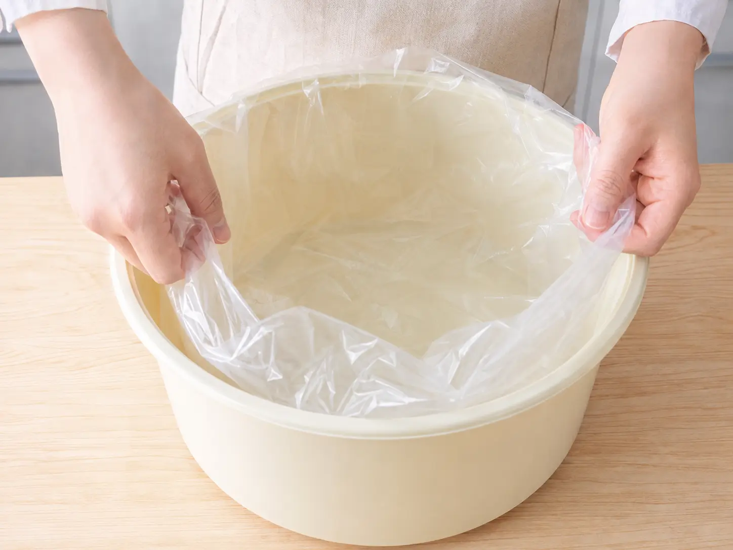 大型の漬物容器へ食品用ポリ袋を敷く手元
