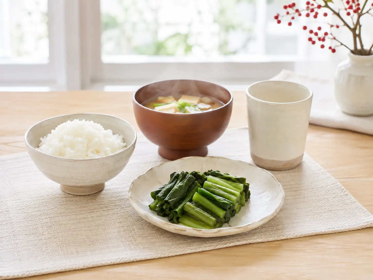生成りの器へ盛った野沢菜漬け、ご飯、味噌汁、湯のみを並べた冬の和食卓