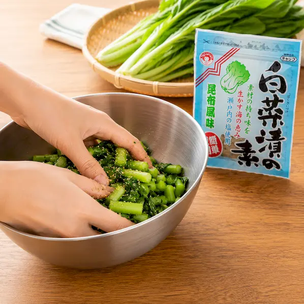刻んだ野沢菜に白菜漬の素を加えて軽くもみ込んでいるイメージ