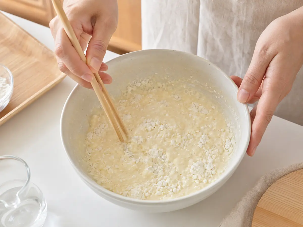 ボウルで卵と冷水を混ぜてから薄力小麦粉を加え、衣を軽く混ぜている工程