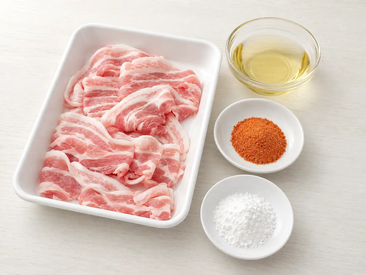 豚バラ薄切り肉200グラム、キムチ漬の素大さじ2、片栗粉大さじ2、揚げ油を並べた材料