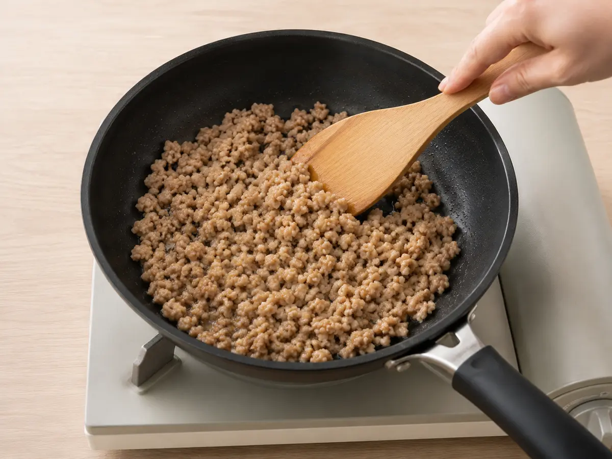 サラダ油を熱したフライパンで豚ひき肉を十分に炒める工程