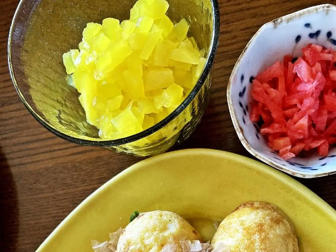 小さく刻んだ黄色いたくあんと紅しょうが、焼き上がったたこ焼きを並べた写真