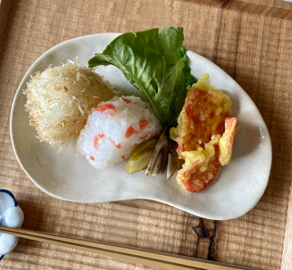 紅しょうが入りのおにぎりや天ぷらを盛り付けた食卓